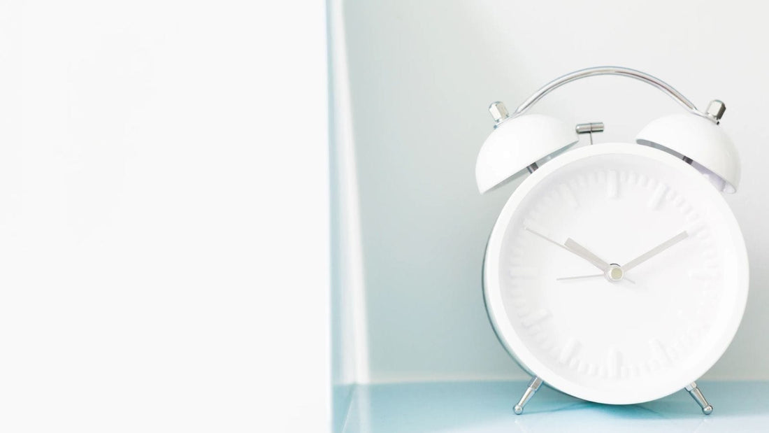 white alarm clock sitting on a table