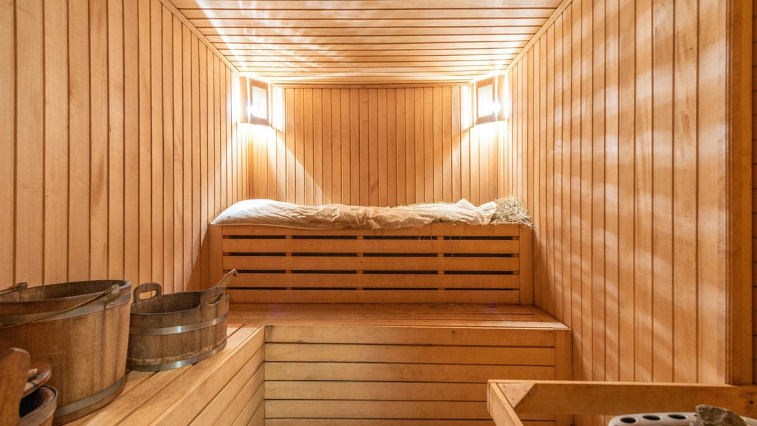 sauna room with light wood and benches with two lights on